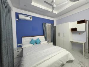 a bedroom with a bed with a blue wall at Evania Pool Suites in Nedumbassery +26 photos