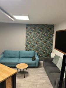 a living room with a blue couch and a tv at La Berge in La Flocellière