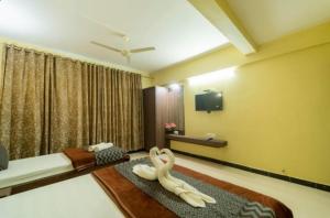 a hotel room with a bed and a tv at Hotel Indira Nature Valley Mahabaleshwar in Mahabaleshwar