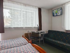 a bedroom with a bed and a table and a couch at Męcikówka in Szczyrk