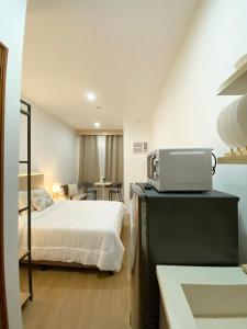 a bedroom with a bed and a microwave on a counter at The Studio Suites in Maribago