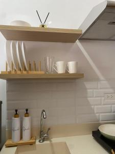 a kitchen with wooden shelves above a sink at The Studio Suites in Maribago