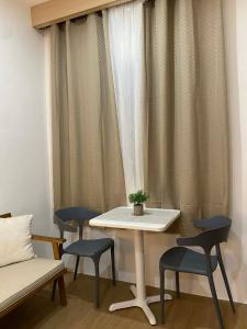 a table and chairs in a room with curtains at The Studio Suites in Maribago