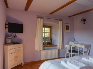 a bedroom with a bed and a desk and a window at Osada Jeździecka Bata in Mirsk
