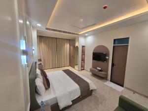 a hotel room with a bed and a television at Hotel Shree Karni Palace in Kishangarh