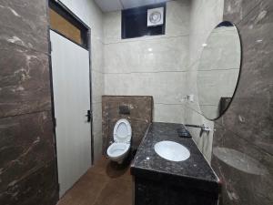 a bathroom with a toilet and a sink and a mirror at Hotel Shree Karni Palace in Kishangarh