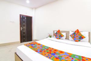 a bedroom with two beds with colorful pillows at FabHotel Vhyom Sky Palace in Kolkata