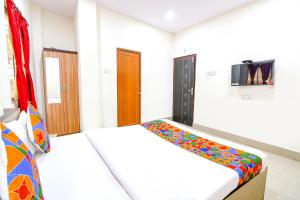 a bedroom with a bed and a tv on the wall at FabHotel Vhyom Sky Palace in Kolkata