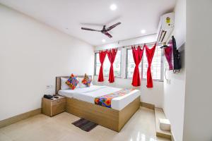 a bedroom with a bed with red curtains at FabHotel Vhyom Sky Palace in Kolkata