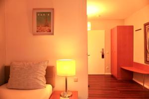 a living room with a couch and a lamp at Hotel Ambiente in Dortmund