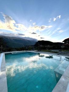 a large swimming pool with a view of the mountains at Guesthouse Lumo & pool in Përmet