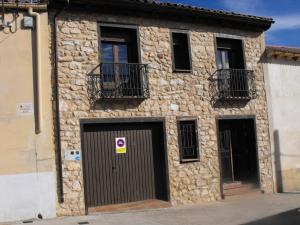 a stone building with two doors and two windows at CASA RURAL ALTA YUBERIA in Berlanga de Duero