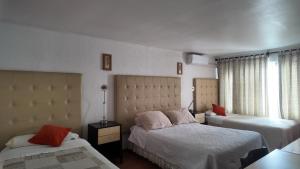 a hotel room with two beds and a window at Chilhotel en Providencia in Santiago +40 photos