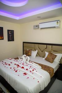 a bedroom with a bed with red rose petals on it at The Manor Inn in Phagwāra