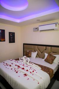 a bedroom with a bed with red rose petals on it at The Manor Inn in Phagwāra +7 photos