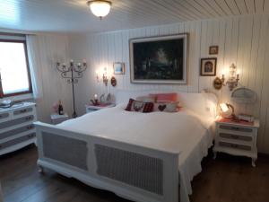 a bedroom with a large white bed with pillows at Chalet Chic mit Hot Pot in Wildhaus