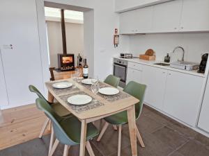 a kitchen with a table with chairs and a stove at Casa da Delonga in Nordeste