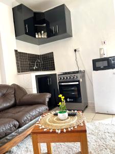 a living room with a couch and a table at Rustic studio milimani in Kisumu