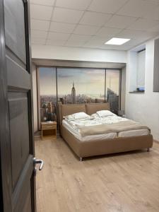 a bedroom with a bed in front of a large window at Silver Dream Apartmanház in Debrecen