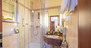 a bathroom with a shower and a sink at PLAZA INN Schmöker-Hof in Norderstedt