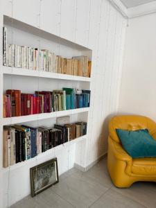 a yellow couch in a room with books at Silver Dream Apartmanház in Debrecen