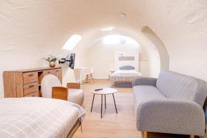 a bedroom with a bed and a couch and a table at Pension Elisa in Bad Friedrichshall