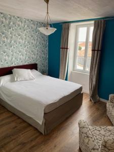 a bedroom with a bed and a window and a chair at L'Olivier in Charron