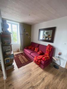 a living room with a purple couch and two chairs at L'Olivier in Charron