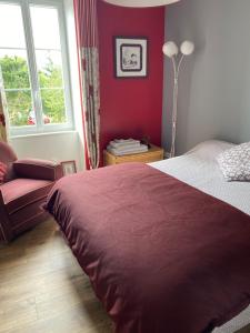 a bedroom with a bed and a chair and a window at L'Olivier in Charron