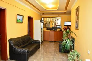 a waiting room with a leather couch and a refrigerator at Hotel Kvareli in Tbilisi City