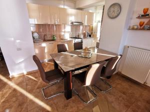 a dining room table and chairs in a kitchen at Elisa Summerland Apartment in Mamaia