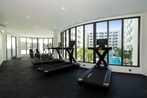 a gym with several treadmills and a large window at Capri Residence Bangtao in Bang Tao Beach