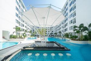 an apartment building with a swimming pool and a fountain at Capri Residence Bangtao in Bang Tao Beach +70 photos