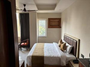a bedroom with a bed and a window at Golden Heights in Dehradun
