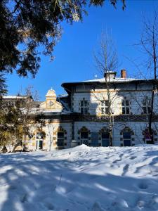 an old building in the snow with a snow covered yard at Parc Vatra Dornei - The 7th Haven in Vatra Dornei