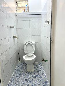 a bathroom with a toilet in a tiled room at Rustic studio milimani in Kisumu