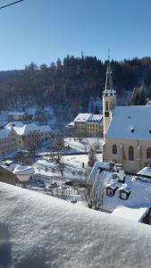 a large building with a steeple in the snow at Apartman Albreit 2 in Jáchymov