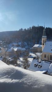 a building covered in snow with a church at Apartman Albreit 3 in Jáchymov