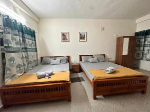 two beds in a room with two beds sidx sidx sidx sidx at Dhruvanish Grand in Sringeri