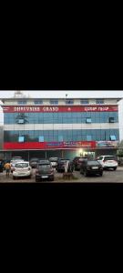 a large building with cars parked in a parking lot at Dhruvanish Grand in Sringeri