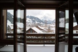 a view of a snowy mountain from a window at Haus Panorama in Schwarzsee