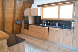 a kitchen with wooden cabinets and a sink and a window at Haus Panorama in Schwarzsee