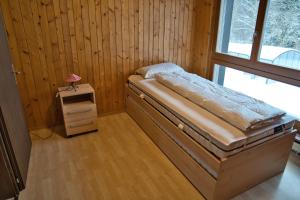 a small bed in a room with a window at Haus Panorama in Schwarzsee