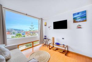 a living room with a large window and a flat screen tv at Costa Azul- 3D Seafront Apartment in Algarrobo