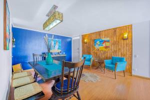 a dining room with blue walls and a table and chairs at Costa Azul- 3D Seafront Apartment in Algarrobo