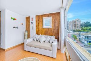 a living room with a couch and a balcony at Costa Azul- 3D Seafront Apartment in Algarrobo