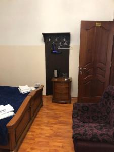 ein Schlafzimmer mit einem Bett, einem Stuhl und einer Tür in der Unterkunft Yan Hotel Erevan in Yerevan