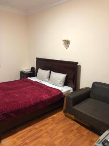 ein Schlafzimmer mit einem roten Bett und einem Sofa in der Unterkunft Yan Hotel Erevan in Yerevan