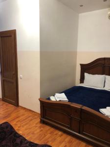ein Schlafzimmer mit einem Bett mit blauen Laken und einer Tür in der Unterkunft Yan Hotel Erevan in Yerevan