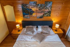 a bedroom with a bed with two lamps and two mirrors at Apartment Dijak in Bohinj